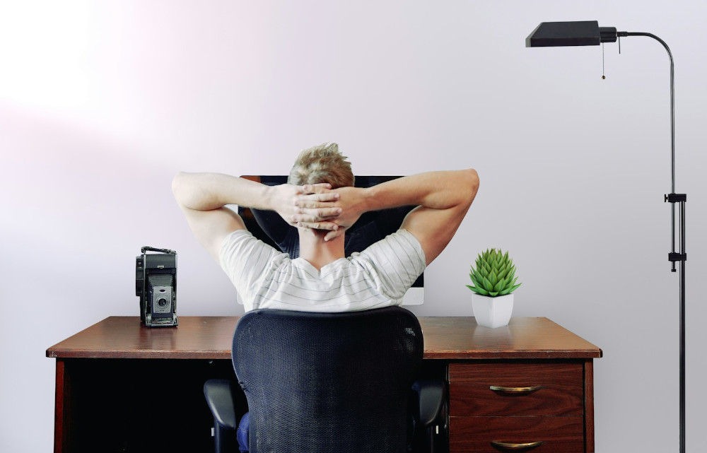 Man relaxed at a desk with a PC in front of him